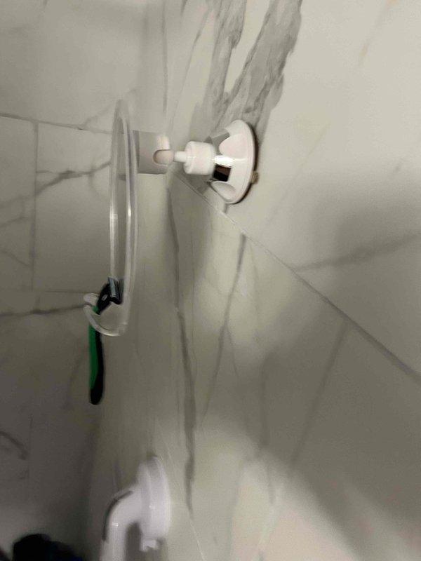 Continued leak investigation with two technicians present. Inspected refrigerator/freezer compartment interior showing visible water damage and vertical staining on white surfaces, along with ceiling-mounted fixture displaying moisture-related discoloration. Documented conditions with photos to identify source and extent of active leak.