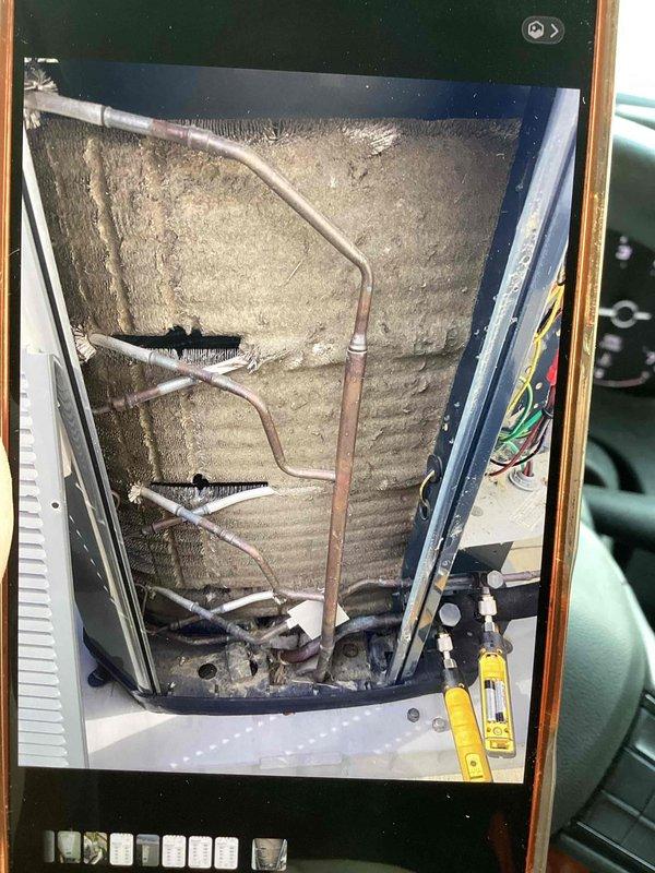 Responded to no cooling call on 2020 Trane XR system with reported clicking noise and suspected blower motor failure. Upon arrival, accessed air handler cabinet and performed diagnostic inspection of internal components including blower assembly, refrigerant lines, and electrical connections. Documented condition of evaporator coil area, copper refrigerant tubing configuration, and insulation integrity for service records.