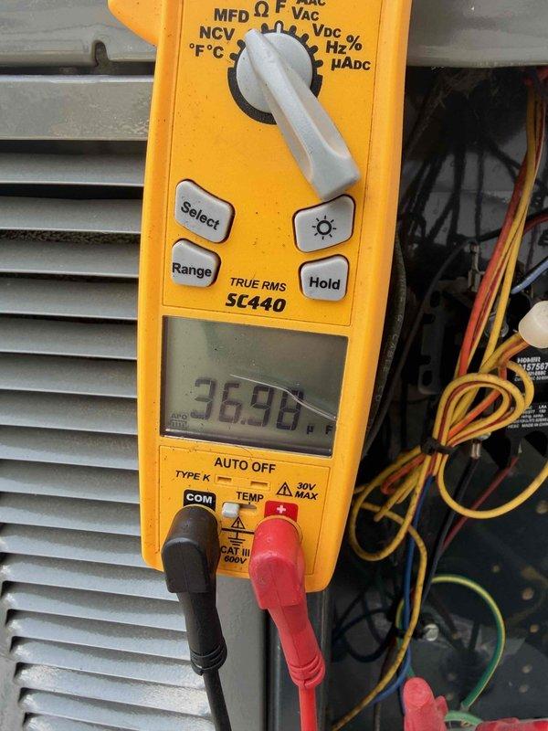 Responded to service call for air conditioning system that had stopped working. Upon arrival, performed diagnostic testing of outdoor unit components rather than proceeding directly with scheduled coil cleaning. Used digital multimeter to test capacitor functionality, measuring 36.96 microfarads on the run capacitor. Inspected electrical connections, contactor operation, and overall system components to determine root cause of system failure before proceeding with any repairs or maintenance work.