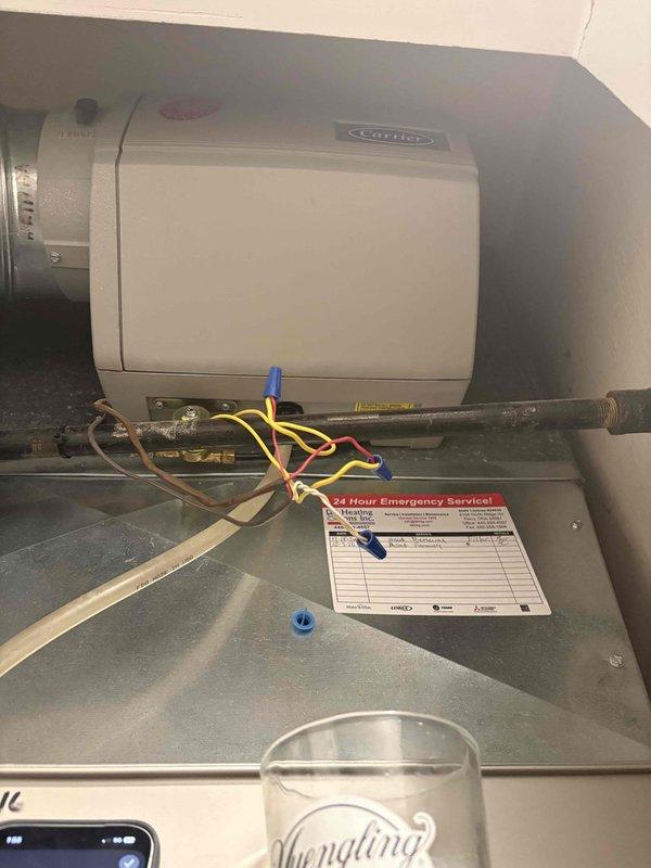 Conducted comprehensive assessment of existing residential HVAC system for replacement estimate. Inspected Carrier air handler unit installed in utility closet alongside A.O. Smith water heater. Evaluated current equipment configuration, ductwork connections, thermostat wiring, and mechanical room layout. Documented equipment conditions, control wiring setup with multiple colored conductors, and existing duct platform installation. Photographed system components and utility space to prepare accurate replacement quote specifications for new air conditioning system installation.