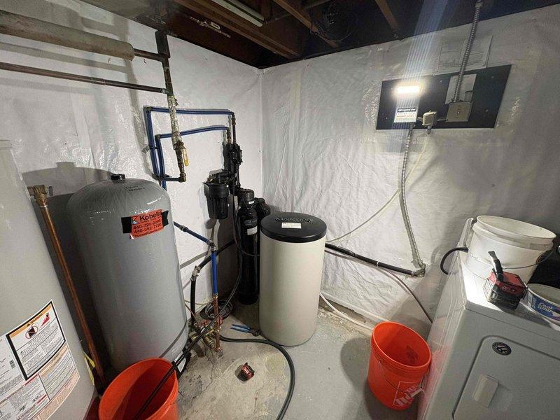 Completed follow-up service for previously sold water treatment system installation. Verified proper operation of dual-tank water softener system with digital controls, confirmed adequate salt supply present in brine tank, and inspected all plumbing connections including copper and PVC piping between water heater, filtration units, and expansion tank to ensure system is functioning correctly and customer can proceed with equipment relocation as planned.