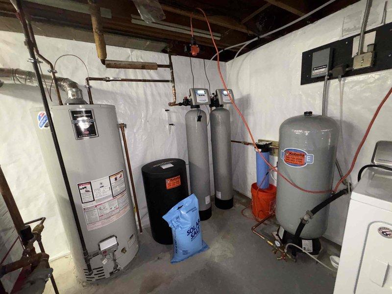Completed follow-up service for previously sold water treatment system installation. Verified proper operation of dual-tank water softener system with digital controls, confirmed adequate salt supply present in brine tank, and inspected all plumbing connections including copper and PVC piping between water heater, filtration units, and expansion tank to ensure system is functioning correctly and customer can proceed with equipment relocation as planned.