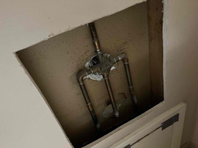 Responded to service call for slow-draining bathroom fixtures in a residential property over 50 years old. Upon arrival, accessed plumbing system through wall-mounted access panel to inspect aging copper supply line configuration. Examined under-sink cabinet area and plumbing connections for blockages and drainage issues. Utilized handheld electronic diagnostic equipment to assess drain flow and identify obstruction points within the aging plumbing system. Inspected visible copper piping showing age-related patina and discoloration consistent with original installation. Addressed drainage concerns in bathroom fixtures by clearing accumulated debris and buildup common in older residential plumbing systems. Verified proper water flow restoration and confirmed all drains functioning at normal capacity upon completion.