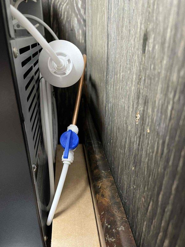 Installed water supply connection for ice maker using copper tubing and compression fittings. Mounted red-handled shut-off valve on chrome fittings to provide dedicated water line control. Routed copper supply line through existing framing and connected to main water supply, ensuring proper support and clearance from electrical components. Tested system for leaks and verified proper water flow to ice maker connection point.