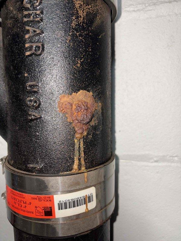 Performed camera inspection of plumbing system to assess condition of Zoeller pump assembly and associated discharge piping. Documentation revealed significant rust corrosion on pump housing with visible staining and deterioration of protective coating, as well as properly installed discharge line configuration with appropriate labeling and monitoring equipment in place.