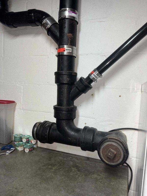 Performed camera inspection of plumbing system to assess condition of Zoeller pump assembly and associated discharge piping. Documentation revealed significant rust corrosion on pump housing with visible staining and deterioration of protective coating, as well as properly installed discharge line configuration with appropriate labeling and monitoring equipment in place.
