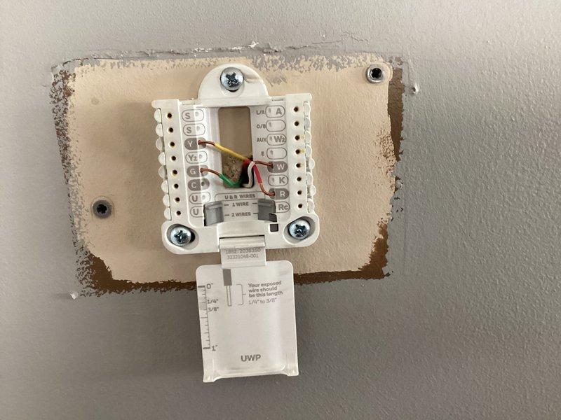 Completed HVAC system evaluation for 19-year-old gas furnace and air conditioning system. Assessed existing ductwork configuration in unfinished ceiling space, documenting metal duct runs and transitions. Inspected wall-mounted thermostat control panel with multi-wire connections and documented current system wiring configuration for replacement equipment specifications.