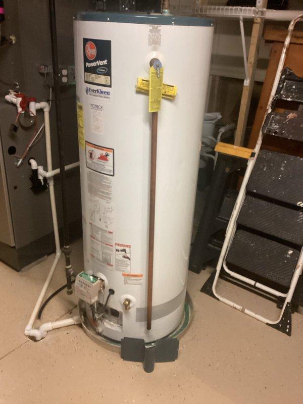 Responded to service call for malfunctioning power vent water heater producing insufficient hot water with continuously running motor and excessive noise. Upon inspection, identified 12-18 year old PowerVent unit operating beyond typical service life with motor assembly running constantly, indicating likely failure of temperature controls or heating elements. Documented equipment condition with photographs showing complete installation including venting system, plumbing connections, and surrounding mechanical equipment. Assessed humidifier system also reported as continuously operating despite control adjustments, requiring separate evaluation of control circuitry and water supply components. Advised customer that age and symptoms indicate imminent system failure requiring replacement of water heater unit to restore proper hot water delivery and eliminate safety concerns associated with continuous motor operation.
