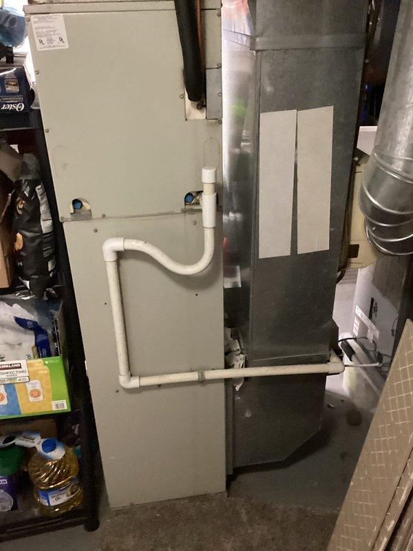 Conducted comprehensive evaluation of aging residential air conditioning system that had not received maintenance in over five years. Inspected outdoor condensing unit, indoor air handler with PVC condensate drainage system, and associated ductwork in basement mechanical room. Assessed system age, operational efficiency, and overall condition to determine viability of continued operation versus replacement. Documented existing equipment configuration including gray metal furnace cabinet, cream-colored air handler unit, silver metallic ductwork, and humidifier installation. Prepared detailed estimate for energy-efficient replacement system to improve cooling performance and reduce operating costs.