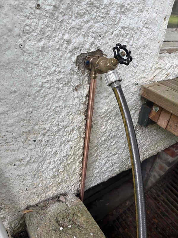Completed plumbing repair installation for apartment and pool house water supply systems. Installed new exterior water spigot with brass valve body and decorative wheel handle, connected copper supply line and braided stainless steel flexible hose to exterior wall mounting. Modified interior utility room ceiling access to install dual PVC water supply lines with shutoff valves connected to water heater system, requiring structural opening for proper pipe routing and valve accessibility.