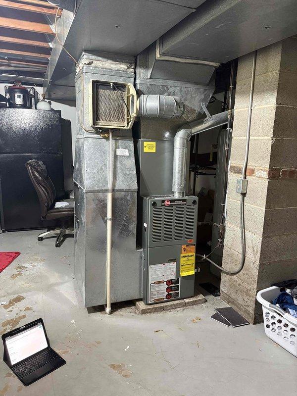 Conducted comprehensive site evaluation for air conditioning system replacement at owner-occupied residence. Existing outdoor AC unit has exceeded 20-year service life and requires replacement. Assessed current HVAC infrastructure including Rheem furnace installation, air handler with filter access, and existing ductwork configuration in basement utility area. Documented equipment specifications, existing plumbing connections including PVC condensate drainage system, electrical routing, and spatial considerations for new equipment installation. Photographed current system layout and surrounding infrastructure to develop accurate replacement proposal and ensure proper equipment sizing for seamless integration with existing forced air system.