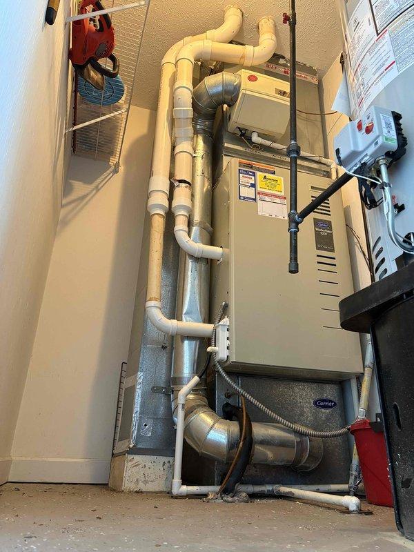Evaluated existing Carrier WeatherMaker 9200 furnace and air handler system experiencing inadequate cooling with lukewarm air circulation. Documented current HVAC installation including furnace unit, PVC venting configuration, ductwork connections, and electrical components in utility space. Provided comprehensive replacement estimate for upgraded heating and cooling equipment to restore proper system performance and temperature control.