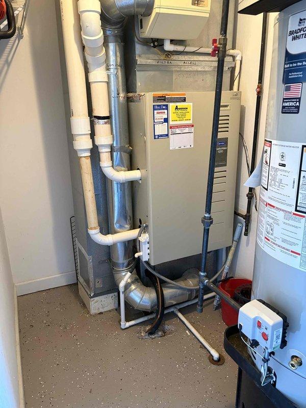 Evaluated existing Carrier WeatherMaker 9200 furnace and air handler system experiencing inadequate cooling with lukewarm air circulation. Documented current HVAC installation including furnace unit, PVC venting configuration, ductwork connections, and electrical components in utility space. Provided comprehensive replacement estimate for upgraded heating and cooling equipment to restore proper system performance and temperature control.