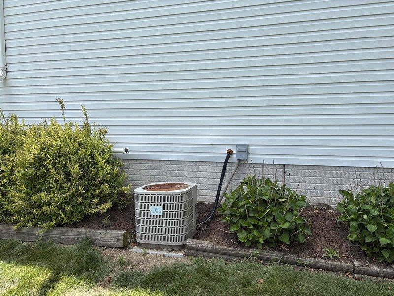 Completed HVAC system evaluation for replacement estimate on a 22-year-old furnace and air conditioning system that is no longer operational. Assessed existing outdoor condenser unit with visible age-related deterioration, including corroded refrigerant line fittings and weathered components. Documented current system configuration, electrical disconnect panel, and refrigerant line routing for comprehensive replacement proposal.