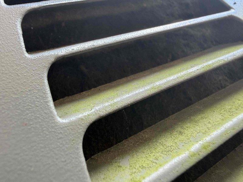 Responded to service call for air conditioning system not cooling adequately. Upon inspection, found outdoor condenser unit with heavily soiled exterior grille, extensive cobweb accumulation, and significant debris buildup restricting airflow. Condenser coil exhibited yellow-green biological growth consistent with mold or algae contamination, along with dirt accumulation between fins. Performed thorough cleaning of condenser coil using approved coil cleaner to remove biological growth and debris. Cleared exterior grille of obstructions and removed accumulated dirt from unit housing. Restored proper airflow through condenser coil by straightening fins and ensuring unobstructed ventilation. System tested and confirmed improved cooling performance following maintenance procedures.