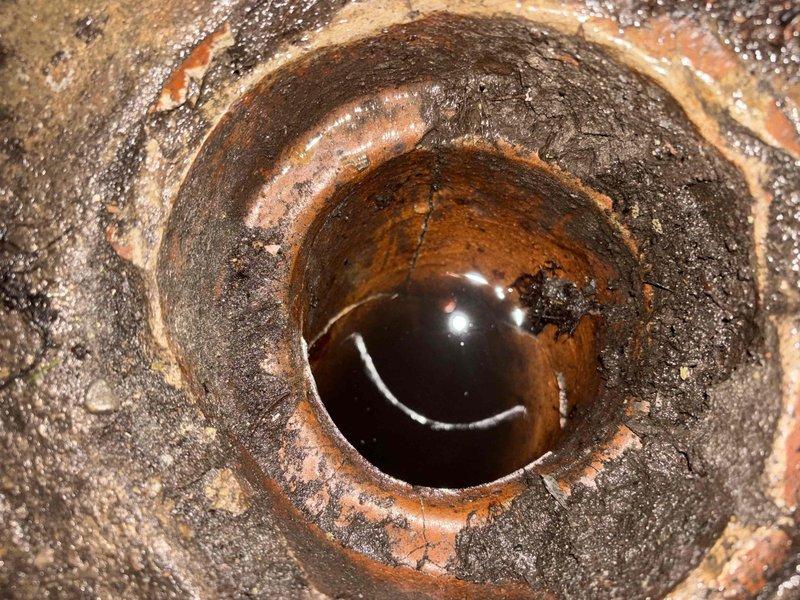Performed video camera inspection of underground drain system to assess interior pipe condition. Documentation revealed severe corrosion, heavy rust buildup, and mineral deposits throughout the pipeline, with visible deterioration of metal surfaces and compromised structural integrity requiring further evaluation.