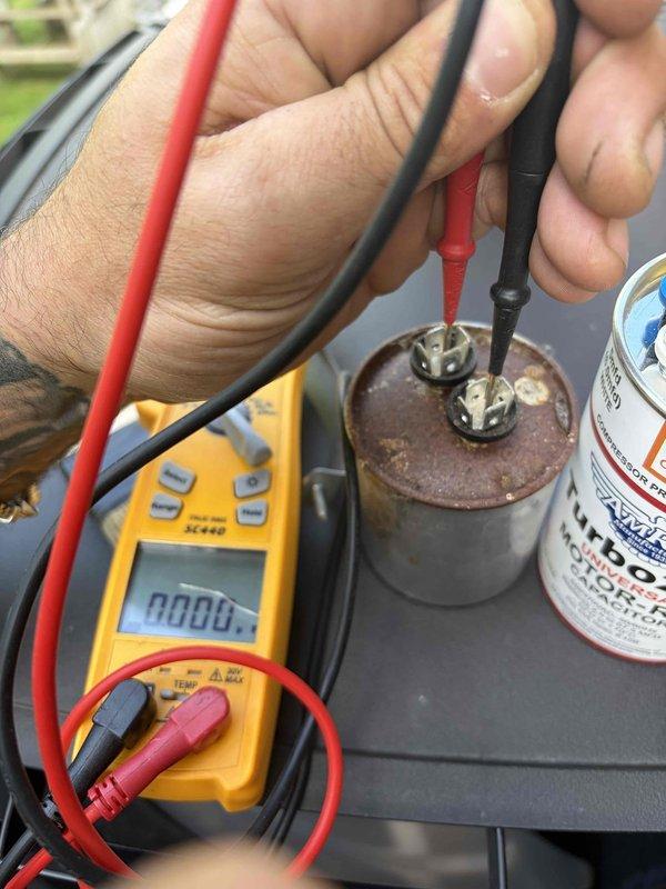 Responded to no cooling complaint on air conditioning system. Upon arrival, diagnosed failed dual-run capacitor serving the compressor and condenser fan motor. Tested capacitor with multimeter, confirming zero microfarad reading on both the 20mfd and 25mfd sections. Replaced defective capacitor with new dual-run capacitor rated at 20/25mfd per manufacturer specifications. Verified proper electrical connections, tested system operation, and confirmed unit returned to normal cooling function.