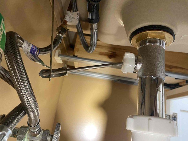 Responded to follow-up service call for slow-draining sink following previous pop-up assembly installation. Upon inspection, verified proper installation of chrome drain assembly and P-trap configuration with appropriate white plastic compression fittings. Tested drainage flow and confirmed all plumbing connections were secure and functioning within normal parameters.