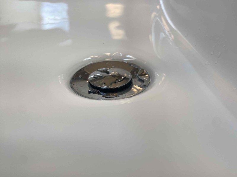 Responded to follow-up service call for slow-draining sink following previous pop-up assembly installation. Upon inspection, verified proper installation of chrome drain assembly and P-trap configuration with appropriate white plastic compression fittings. Tested drainage flow and confirmed all plumbing connections were secure and functioning within normal parameters.
