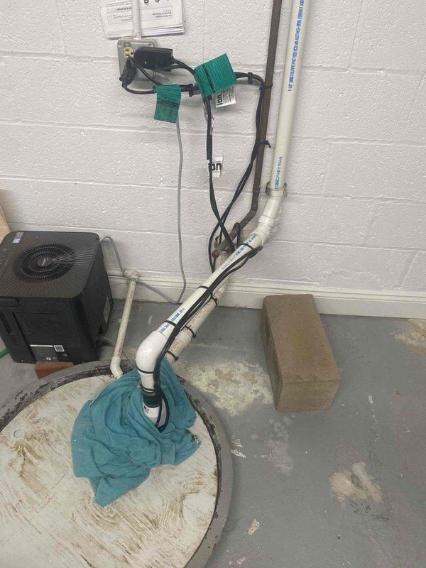 Removed existing battery backup sump pump system and installed new electric-powered unit with 65-watt ampere-hour capacity. Verified proper operation of dual sump pump configuration with PVC discharge piping, check valves, and electrical connections to ensure reliable basement water management and flood protection.