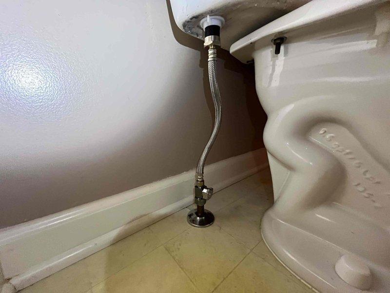Responded to a toilet leak originating from the fill valve assembly. Upon inspection, identified a deteriorated braided stainless steel supply line requiring replacement. Replaced the faulty supply line connecting the wall-mounted shut-off valve to the toilet tank fill valve with new braided flex line, ensuring proper connections at both the angle stop and fill valve shank. Tested system for leaks and verified proper fill valve operation and water flow.