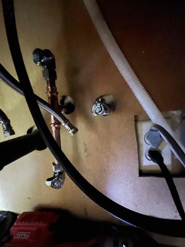 Installed new pull-down kitchen faucet with brushed nickel finish and single-handle operation in double-basin stainless steel sink. Replaced both hot and cold water shut-off valves under sink with new chrome fixtures and connected supply lines to ensure proper water flow and prevent future leaks.
