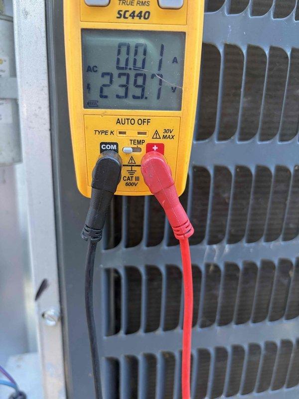 Completed cooling maintenance club visit on air handler unit. Performed electrical diagnostics using digital multimeter, recording voltage at 239.1V AC and current draw at 0.01A, indicating system electrical parameters within normal operating range. Conducted thorough inspection of condenser coil assembly, identifying substantial accumulation of dirt, dust, and debris lodged between aluminum fins. The heavy soiling was restricting airflow and reducing heat transfer efficiency. Documented unit condition with photographs for maintenance records. System accessible and operational at time of service.