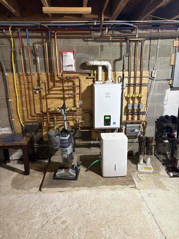 Conducted site evaluation for adding cooling to unconditioned basement space with no existing ductwork or AC coverage. Assessed mechanical room configuration, existing heating system infrastructure, and current thermostat wiring to determine feasibility and requirements for ductless mini-split installation as primary cooling solution for the area.