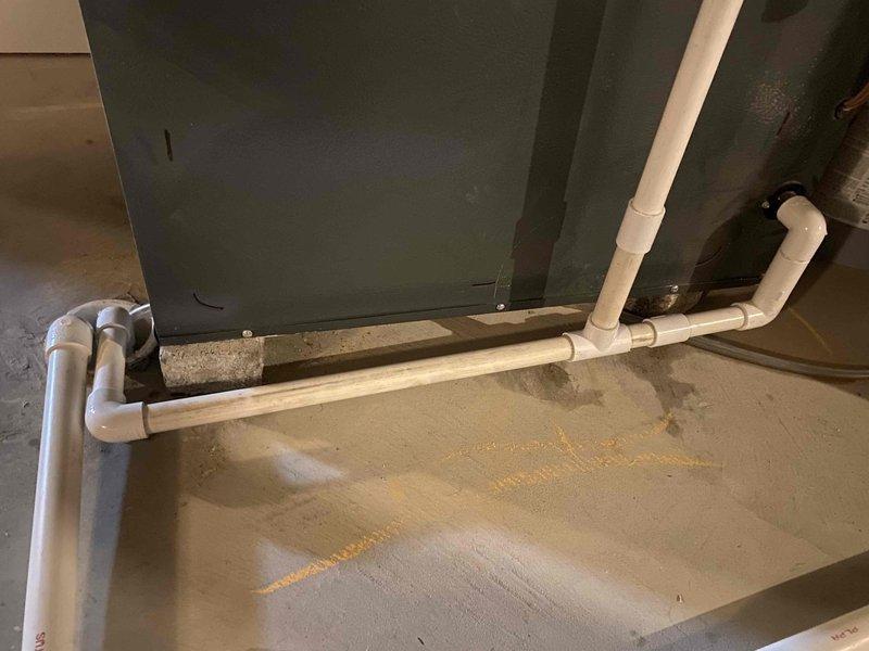 Responded to emergency call for sewage leak in basement of two-year-old home. Upon inspection, identified active sewage discharge on concrete floor near drainage system with visible water damage and staining. Assessed PVC drainage piping configuration along foundation wall, documented conditions with photographs showing horizontal drain lines with multiple fittings and vertical stack connections. Determined source of leak, performed necessary repairs to restore proper drainage function, and verified system integrity to prevent further sewage infiltration into living space.