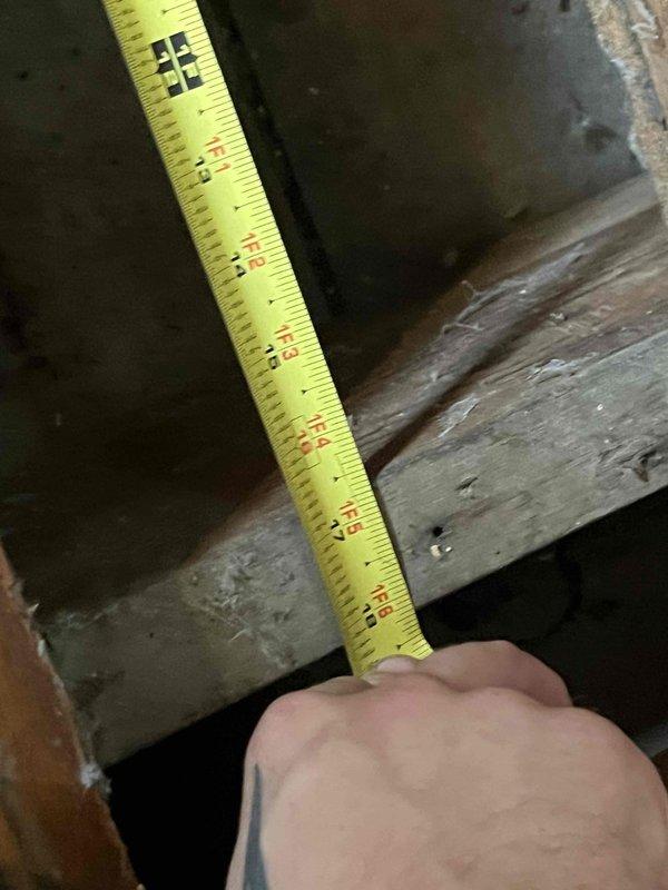 Conducted indoor air quality evaluation of existing floor-mounted cold air return system, estimated to be 60-70 years old. Performed inspection of ductwork infrastructure including crawl space access to assess condition of wooden structural components and measure dimensions for potential metal sheet lining installation. Documented existing floor register condition and surrounding wood flooring, noting age-related wear patterns around vent opening.