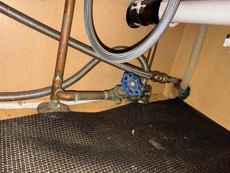 Responded to callback for kitchen sink faucet with insufficient clearance preventing full range of motion from hot to cold positions. Inspected pull-down chrome faucet installation and verified limited swing radius due to positioning constraints. Cleared clogged kitchen sink drain that customer had previously attempted to treat with chemical drain cleaners without success. Confirmed no additional drains were affected. Cleared blockage and restored proper drainage function. Documented under-sink plumbing configuration including braided supply lines, copper piping, and shut-off valves for future reference.