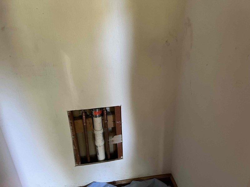 Accessed plumbing system through closet wall by cutting drywall access panel to expose corroded copper supply lines. Replaced deteriorated copper piping with new copper pipe and fittings, installed chrome shut-off valves, and connected braided stainless steel flexible supply lines to fixture. Verified proper water flow and tested all connections for leaks before completing installation.