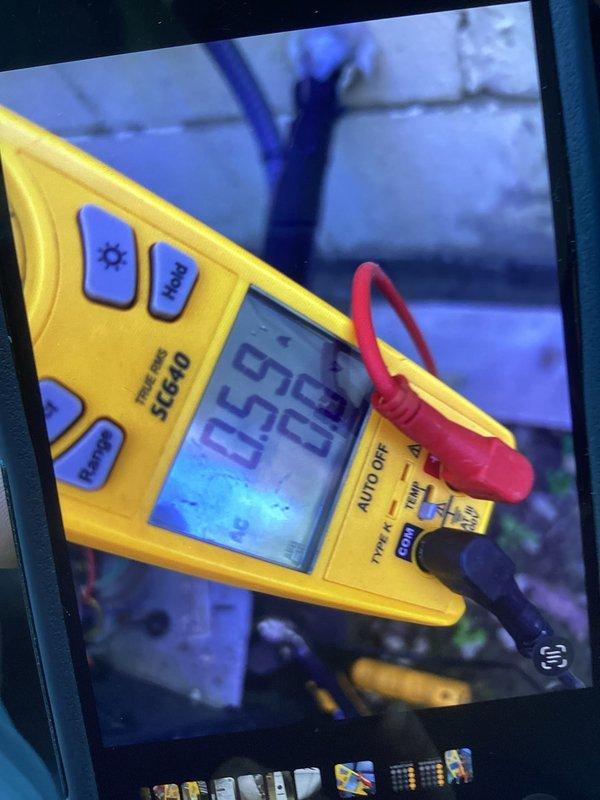 # HVAC Service Call - No Cooling Complaint

Responded to no cooling complaint on residential air conditioning system installed in 2020. Upon arrival, performed diagnostic testing using digital multimeter to assess system performance and identify root cause of cooling failure.

Conducted electrical measurements at the outdoor condensing unit, checking voltage and amperage readings to verify proper power supply and component operation. Multimeter readings indicated values of 0.50 and 25 during initial testing phase, with subsequent readings showing 99.6 and 8.1 during component evaluation. Testing focused on critical electrical components including contactor, capacitor, and compressor circuits.

Documented diagnostic findings with photographs showing meter readings and equipment condition for service records. Scheduled service visit accommodated customer's work schedule availability. System evaluation completed and appropriate corrective action determined based on electrical testing resu