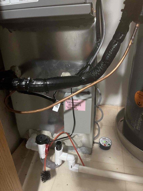 Completed full HVAC system installation including new air conditioning unit and evaporator coil in residential utility room. Installed new air handler with insulated refrigerant lines and flexible ductwork, integrated condensate drain assembly with PVC piping, and ensured proper connection to existing furnace system. All components tested and operational upon completion.