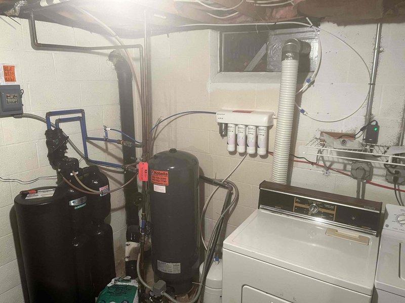 Responded to complaint of rotten egg odor in hot water at recently purchased residence. Inspected tanked water heater installation in basement utility room and evaluated water quality concerns. The sulfur smell typically indicates bacterial growth in the water heater tank or reaction between anode rod and water supply. Provided customer education on cause of odor and recommended treatment options including anode rod replacement or tank flushing. Additionally provided consultation and quotation for reverse osmosis water filtration system installation to address overall water quality concerns throughout the home.