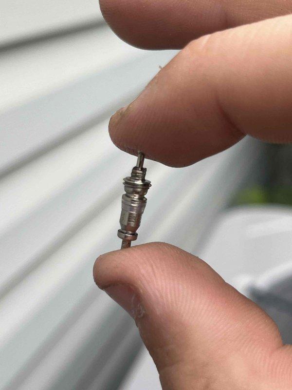 Returned to property to perform leak search on recently installed HVAC system due to recurring issue that was present on previous unit. Located and identified leaking Schrader valve core on refrigerant line. Removed defective valve core and installed new replacement component to eliminate refrigerant leak. Tested system for proper operation and verified repair resolved the issue. Documented removed parts with photos for warranty consideration.