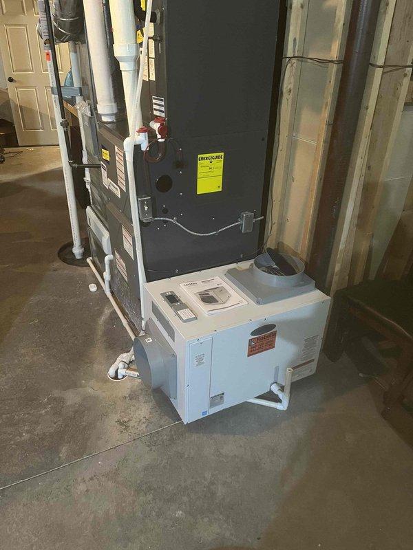 Completed installation of whole home dehumidifier system in basement utility area. Unit was mounted and integrated with existing HVAC infrastructure, including connection of refrigerant lines, PVC drainage piping, and electrical controls. System tested and operational upon departure.