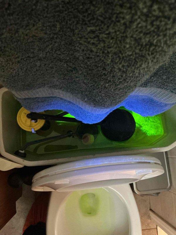 Responded to plumbing maintenance visit for member reporting quadrupled water bill indicating potential leak. Performed diagnostic dye test using fluorescent tracer in toilet tank and plumbing system to identify source of water loss. Inspection revealed internal toilet leak with dye visible in bowl, confirming faulty flapper valve or flush valve assembly causing continuous water flow and excessive water consumption.