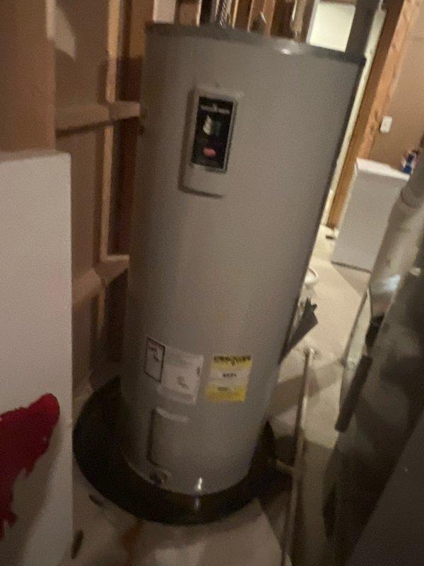 Responded to service call for tanked water heater experiencing bottom leakage. Upon arrival, assessed unit condition and documented existing water heater installation in basement utility area. Water heater was positioned on drip pan with visible signs of water discharge from lower tank section. Photographed unit specifications, control panel, and surrounding installation area for service records. Provided customer guidance on emergency shut-off procedures for cold water supply valve and instructed to run hot water taps to relieve system pressure and minimize flooding risk until replacement could be scheduled.