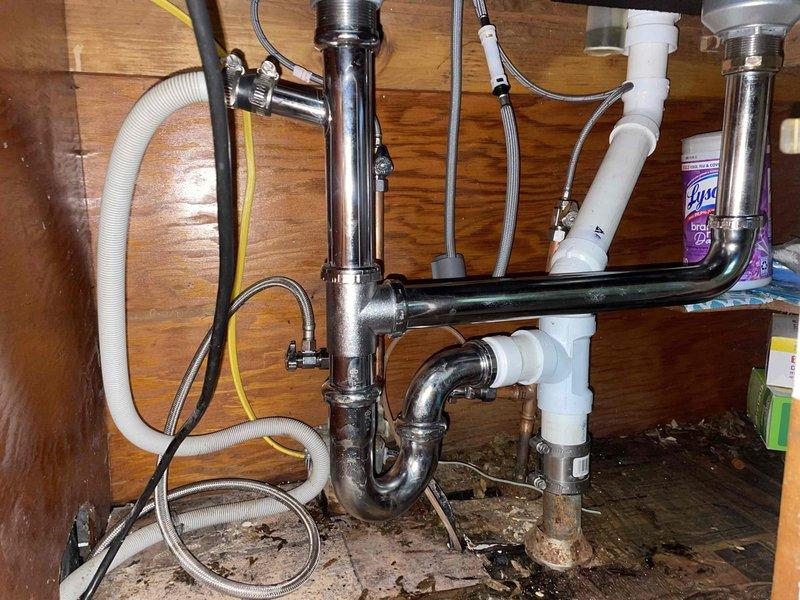 Returned to property to complete water heater replacement and kitchen plumbing rework as previously sold. Successfully installed new State brand water heater with expansion tank, properly connected all copper supply lines and verified system pressurization. Completed kitchen sink drain line rework, replacing deteriorated components with new chrome P-traps and PVC drainage assembly to address existing water damage visible in cabinet base. All connections tested and verified leak-free, systems operational.