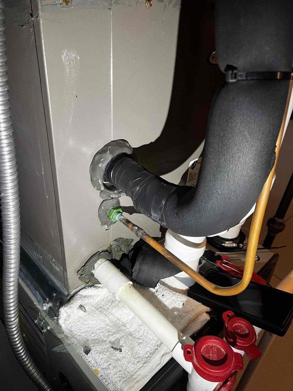 Responded to callback for water accumulation at air handler location. Upon inspection, discovered excessive frost buildup on condensate drain line and deteriorated insulation on refrigerant lines, indicating potential drainage restriction or airflow issue. Documented system conditions with photographs showing ice formation on PVC drain piping and compromised pipe insulation throughout the mechanical assembly.