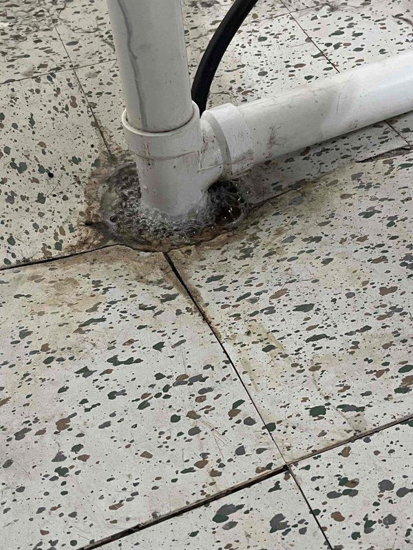 Responded to a slow-draining laundry drain complaint. Performed video camera inspection of the drain line, advancing the camera approximately 20 feet into the system to identify the cause of the backup. Inspection revealed accumulated sludge and debris within the pipe causing restricted flow. The drain line, consisting of white PVC piping with floor penetration in a terrazzo-floored area, was successfully assessed and the blockage location documented for clearing.