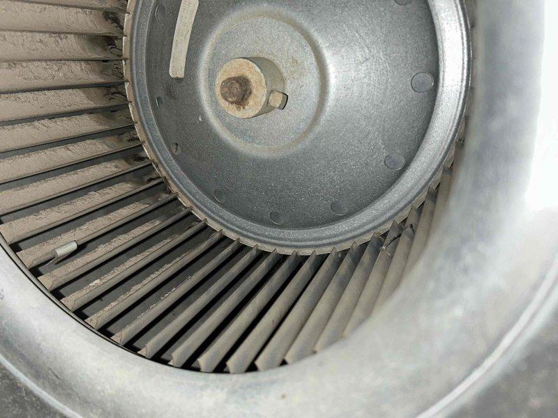 Performed cooling maintenance on club member system with reported temperature imbalance between upper and lower floors. Inspected air handler and ductwork in attic space, documenting flexible duct connections and insulated components. Examined blower wheel assembly, noting dust accumulation on blades and minor corrosion at central mounting hub. Addressed airflow concerns related to upstairs cooling deficiency.