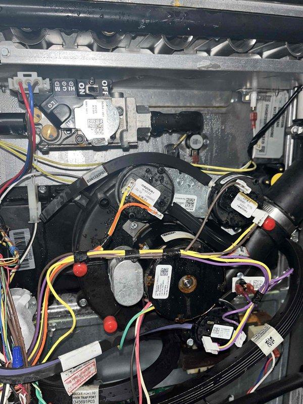 # HVAC Service Completed

Responded to a whole-home air conditioning outage on a 4-year-old AC system. Upon inspection, discovered significant condensate drainage issues with visible water accumulation throughout the equipment compartment. The condensate drain line showed excessive moisture buildup with water droplets hanging from piping, and standing water was present on the drain pan surface. 

Cleared the blocked condensate drain line to restore proper drainage flow. Verified all blower motors and electrical connections were intact and functioning properly despite moisture exposure. Inspected the heat exchanger assembly, control module, and wiring harnesses for any water damage or compromised connections. Tested system operation and confirmed cooling functionality was restored. All components returned to normal operating condition with proper condensate drainage re-established.