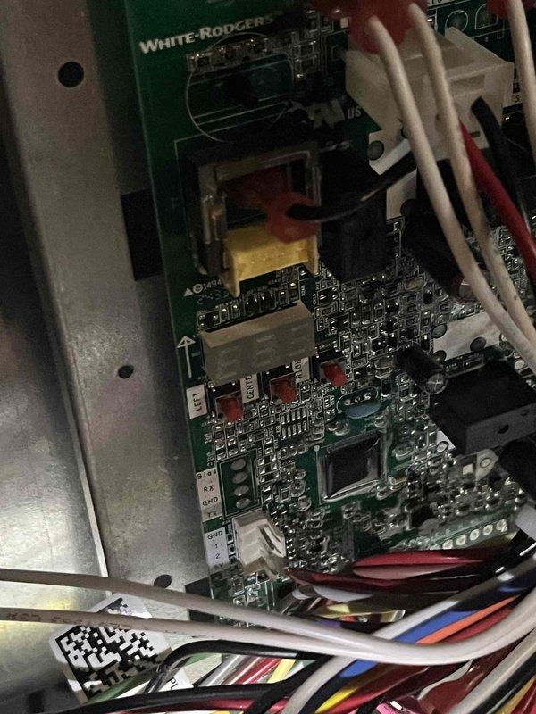 Performed diagnostic inspection of HVAC system and White-Rodgers control board assembly. Documented existing conditions including clogged gutter system with accumulated leaf debris near exterior unit and verified proper wiring connections and component functionality on the circuit board. System operational at time of service completion.