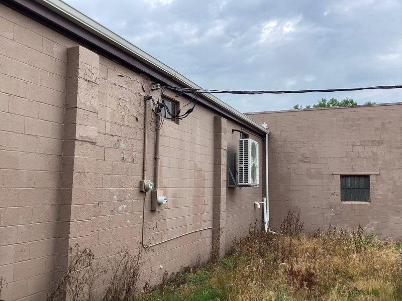 Conducted site evaluation for mini split system installation at 1500-1600 square foot machine shop facility with concrete block construction. Assessed existing cooling infrastructure, including window-mounted AC unit, and evaluated electrical service capacity and optimal placement locations for indoor and outdoor mini split components to provide adequate climate control for the workspace.