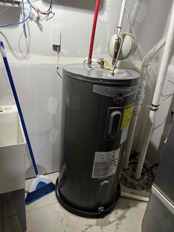 Completed maintenance service on Rheem Performance tanked water heater. Performed flush and drain procedure to remove sediment buildup from tank, improving efficiency and extending equipment lifespan. Inspected all plumbing connections at top of unit including copper lines, flexible connectors, and PVC piping. Noted garbage disposal drain hose in utility area shows signs of wear and may require future replacement to prevent potential leaks. Verified temperature and pressure relief valve operation and confirmed proper discharge pipe installation. All water heater components functioning within normal parameters upon completion of service.