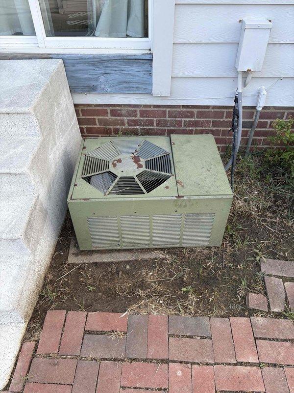 Responded to no-cooling complaint on residential air conditioning system. Upon inspection, found outdoor condensing unit attempting to engage but with no air movement from interior supply registers. Confirmed unit was clicking on at thermostat call but compressor and blower motor were not operating properly. Evaluated aged outdoor unit showing significant weathering and wear, along with basement furnace and ductwork system. Determined system required full replacement due to age and component failure. Provided estimate for complete HVAC system replacement including new outdoor condensing unit and associated equipment.