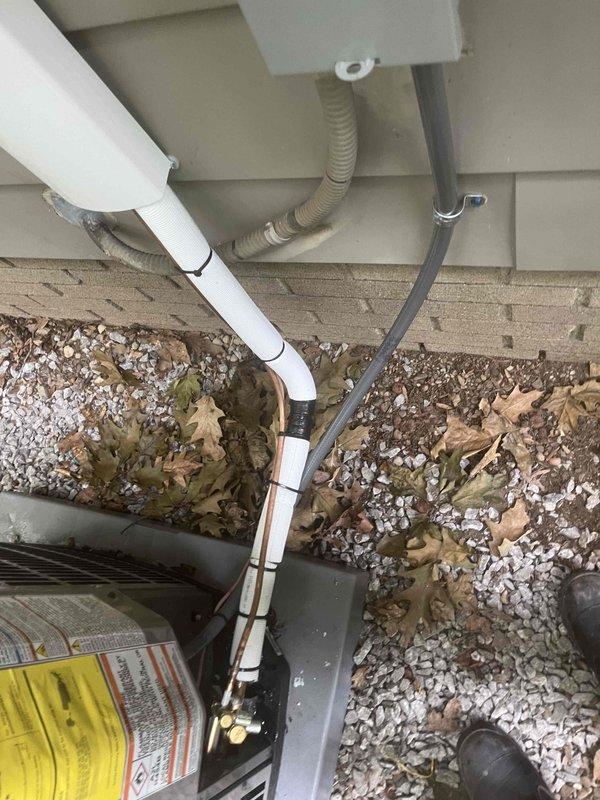 Returned to installation site to correct condenser installation and complete thermostat wiring configuration. Installed N100 thermostat for heating system to complement existing cooling thermostat. Ran 3-wire cable up wall to White Rogers zone valve, secured connections with wire nuts, and verified proper communication between heating thermostat and zone control system.