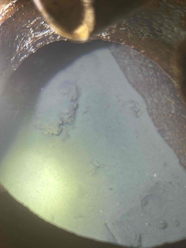 Responded to clogged basement floor drain in 80-year-old residential property. Upon arrival, performed visual inspection of floor drain opening and confirmed complete blockage preventing proper drainage. Utilized mechanical drain snake to clear obstruction from floor drain line, working through accumulated debris and buildup consistent with age of plumbing system. Successfully restored full drainage flow and verified proper operation. Documented pre-service and post-service conditions with photographs showing drain interior and equipment used during service call.
